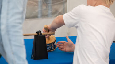 A child holding a percussion instrument