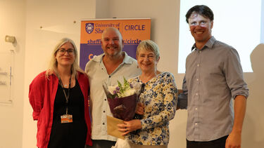 CIRCLE team member pose with professor Sue Yeandle in front of banner