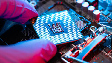 A close up of a CPU being placed on a circuit board