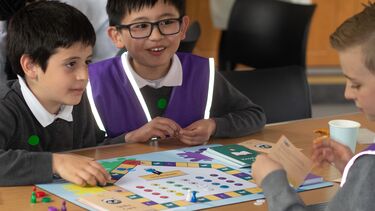 3 school children play Law a board game called Law Yeh
