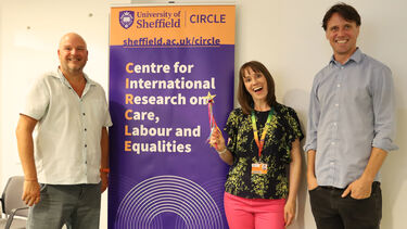CIRCLE Co-Directors and Louise Dore pose for a photo in front of a banner