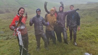 A photo of the Plynlimon team featuring 6 people, stood in a rainy upland field in mid Wales