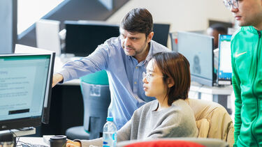 Academic supporting student with computer work