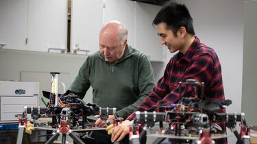 A student and a academic are working on some drones
