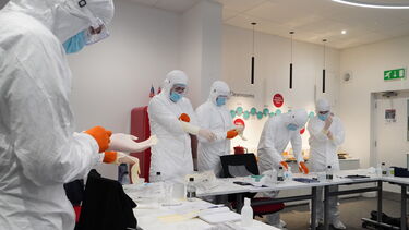 Scientists learning about protective equipment for clean rooms