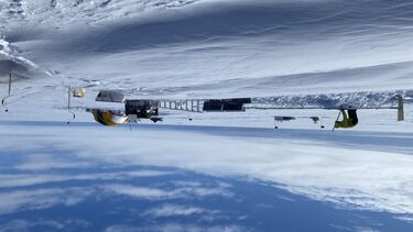 The Picante research team camp site in the Antarctic with tents and someone digging a trench