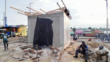 Two builders taking a rest next to an almost finished sustainable cold room