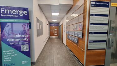 Long corridor with doors at end with Emerge branding