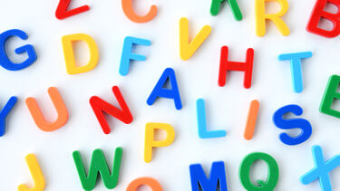 Alphabet blocks arranged at random on white board