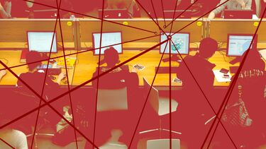 A graphic of people sitting at computers at a desk with red lines overlayed onto the image connecting at various points