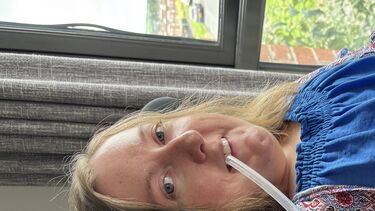 Dr Dr Suzanne Glover in a blue top using mouthpiece ventilation