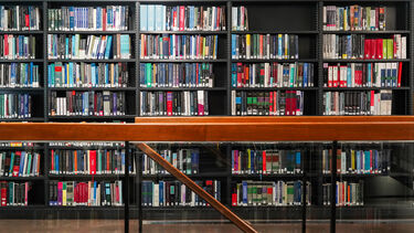 The shelves of books at Western Bank Library with a staircase
