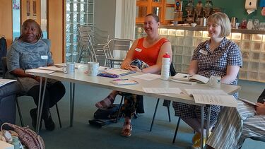 Women sitting at table smiling at workshop