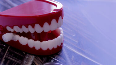 A set of fake teeth on a blue background