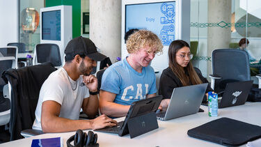 Three students are working together in computer room 3 in the Diamond.