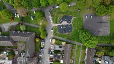 Aerial photograph in the UK featuring houses, cars and a playground