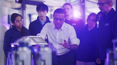 Professor Ash Tiwari shows students a machine