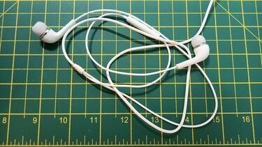 pair of earphones on a green cutting mat