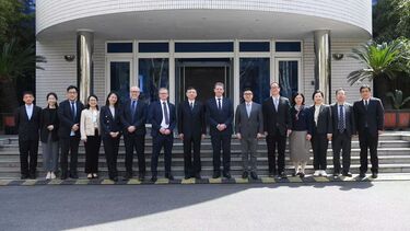 A group of colleagues from the universities of Sheffield and Tongji stand in a row outside a building and smile towards the camera.