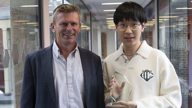 Guannan Hao, holding his Dean's List trophy, standing next to Professor Fraser McLeay.