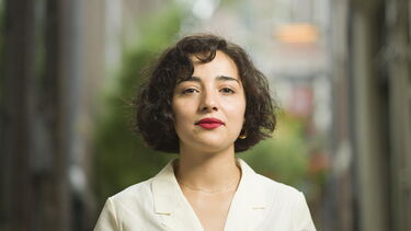 Dutch Author Safae el Khannoussi in a white summery top looking in the camera