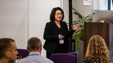 Lenny Koh is speaking in front of an audience