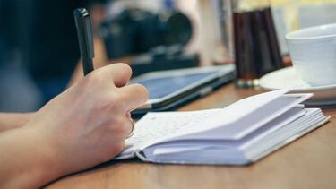 Hands writing in a notebook
