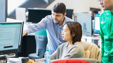 Academic helping student at computer