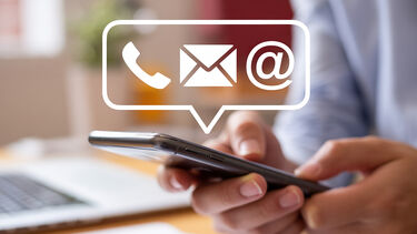 Graphic of person holding a phone with symbols of a phone, email and social media superimposed