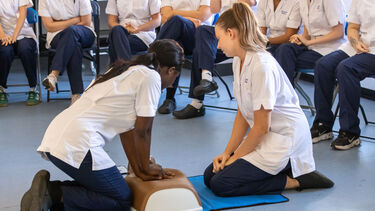 Two nursing students practicing CPR on a Manikin