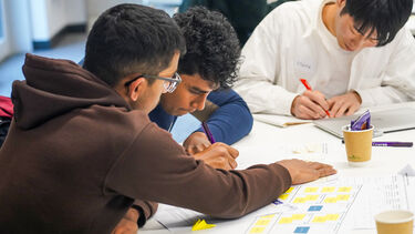 GROUP OF STUDENTS WORKING ON IDEA