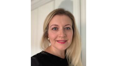 Person smiling at the camera with a white background.