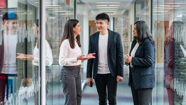 An academic discussing with two students
