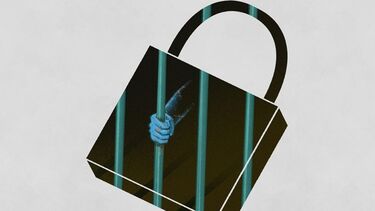 Image of a hand clutching iron bars of a prison window