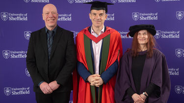 Martin Lewis in gradation robe stands with Sarah Brown and Steve McIntosh