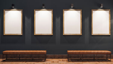 Four empty picture frames stand in a museum. 