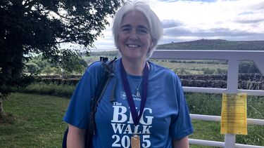 Lucy, a participant in the big walk at home wearing her Big Walk medal and t-shirt 