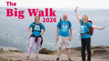 3 people stood smiling wearing The Big Walk 2025 T-shirts. The Big Walk 2026 logo in pink is above the walkers