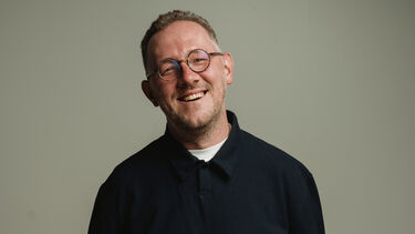 Vladimir Raevskiy stands, smiling, wearing a black shirt