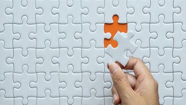 A jigsaw with one final piece being added to the puzzle