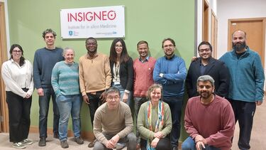 A group of people standing in front of an Insigneo Institute sign.
