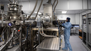 A researcher wearing full clean room PPE 