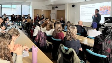 a group of students photographed from behind and a lecturer, Koen Vossen in front of a ppt. screen on populism in the Netherllands 