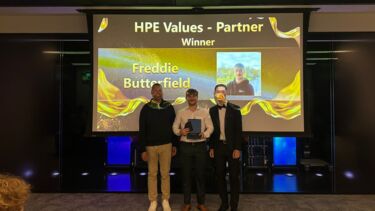 Three people on stage at an awards event