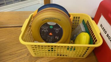 A defibrillator in a yellow basket