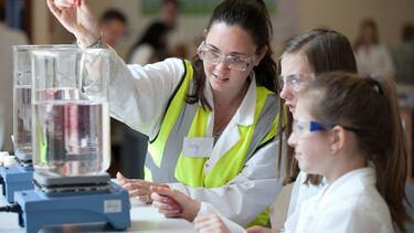 A photo of a teacher doing an experiment with pupils