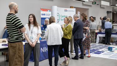 People chat near a large board game on the floor