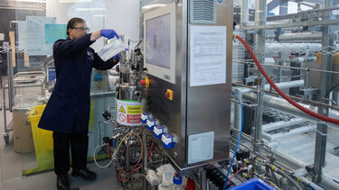 A researcher filling up a fermenting vessel 