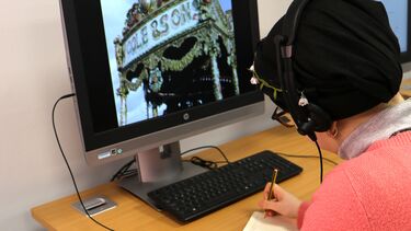 Student at acomputer watching a video fairground ride