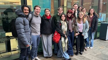 Group of about 12 students smiling and the translator 